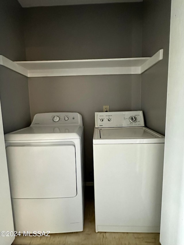 washroom with light hardwood / wood-style flooring and washing machine and clothes dryer