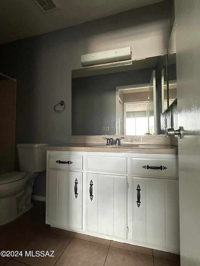 bathroom featuring tile patterned flooring, vanity, and toilet