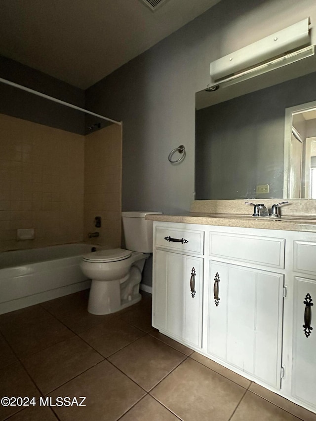 full bathroom with vanity, tiled shower / bath combo, toilet, and tile patterned flooring