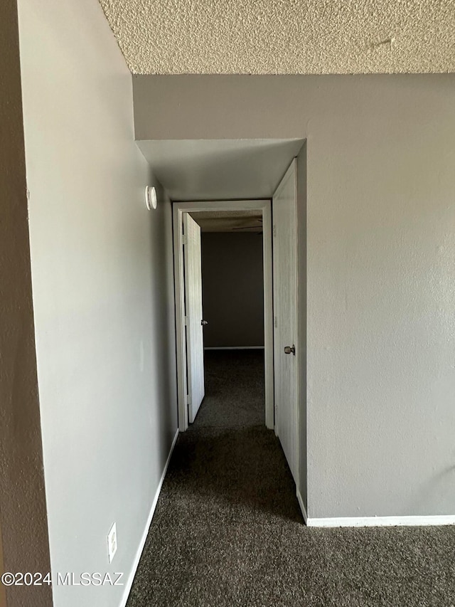 hall featuring dark colored carpet