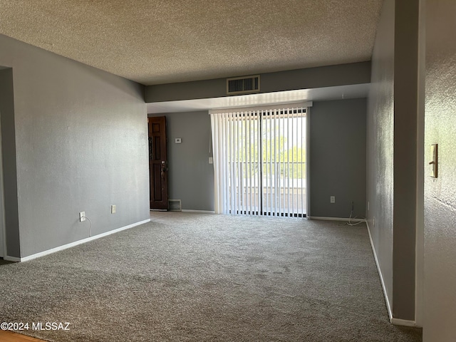 carpeted empty room with a textured ceiling