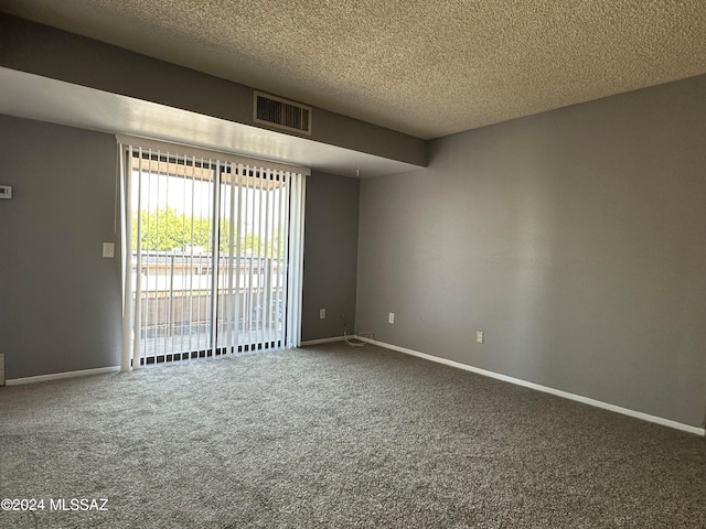 unfurnished room featuring a textured ceiling and carpet flooring