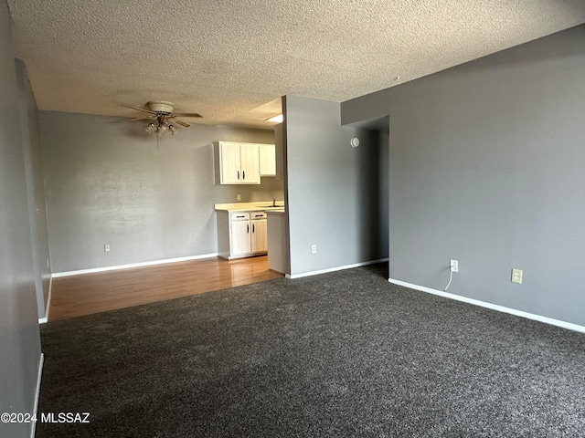 unfurnished living room featuring ceiling fan, a textured ceiling, sink, and dark hardwood / wood-style flooring