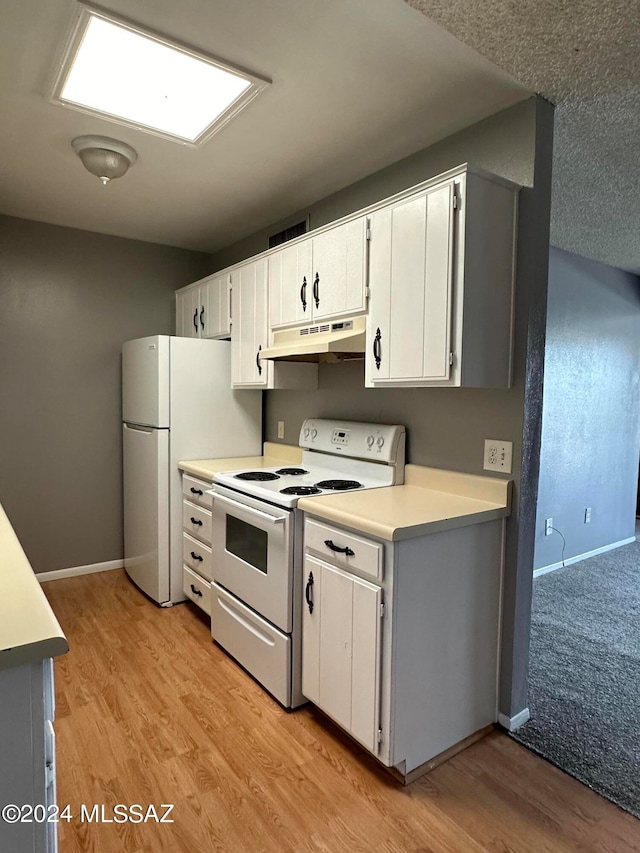 kitchen with white appliances, light hardwood / wood-style flooring, and white cabinets