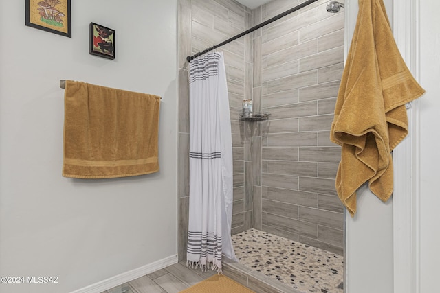 bathroom with hardwood / wood-style flooring and walk in shower