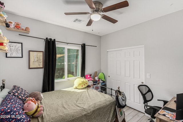 bedroom with a closet, light wood-type flooring, and ceiling fan