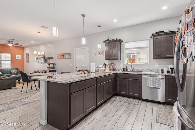 kitchen featuring light hardwood / wood-style floors, stainless steel appliances, hanging light fixtures, and sink