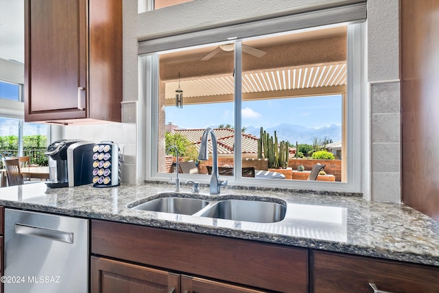 kitchen with a mountain view, sink, dishwasher, and dark stone countertops