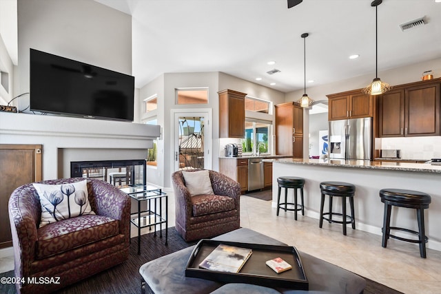 tiled living room featuring a multi sided fireplace and sink