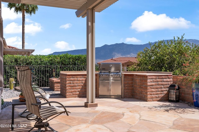 view of patio with a mountain view, area for grilling, and a pergola