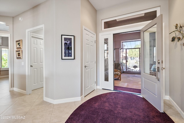 foyer featuring light tile patterned flooring and a healthy amount of sunlight