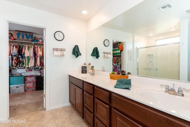 bathroom featuring a shower with shower door, tile patterned floors, and vanity