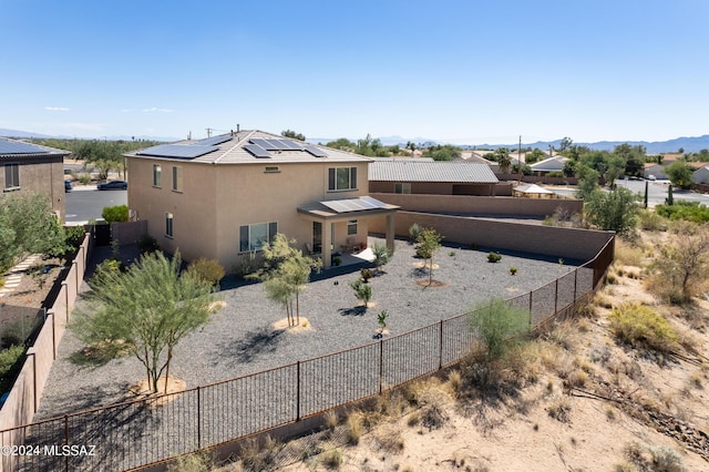 rear view of property with solar panels