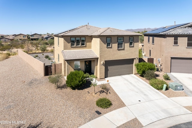 view of front facade with a garage and solar panels