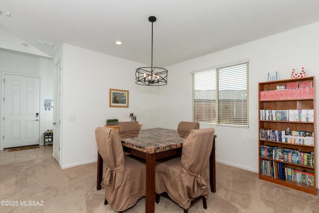 carpeted dining space with a notable chandelier