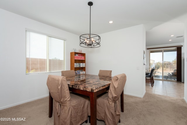 dining room with a wealth of natural light, light carpet, and an inviting chandelier