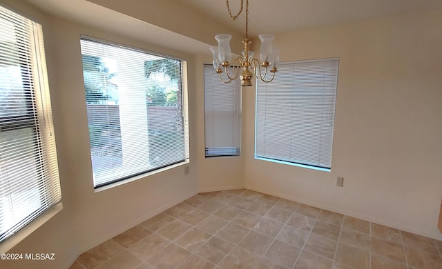 tiled empty room featuring an inviting chandelier