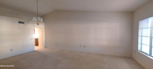 empty room with vaulted ceiling, carpet floors, and a healthy amount of sunlight