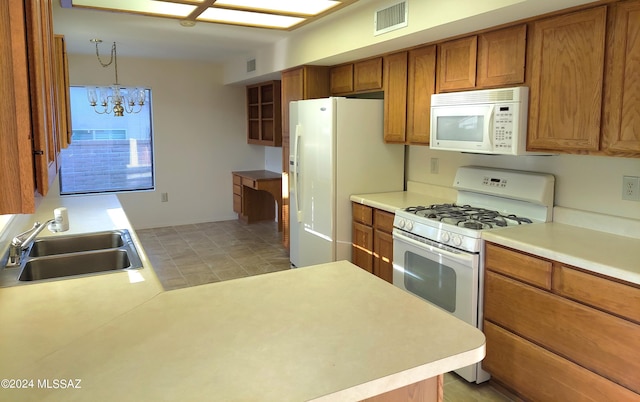 kitchen with a notable chandelier, decorative light fixtures, sink, and white appliances