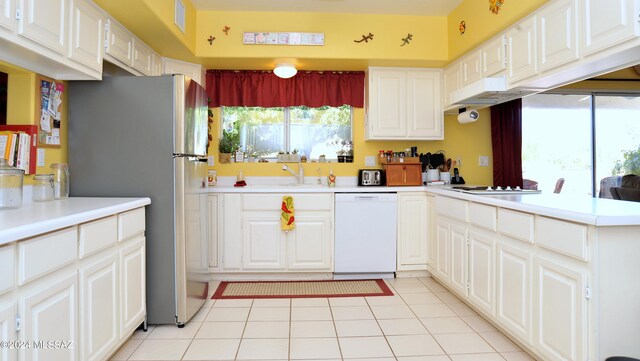 kitchen featuring light tile patterned floors, kitchen peninsula, white appliances, and white cabinetry