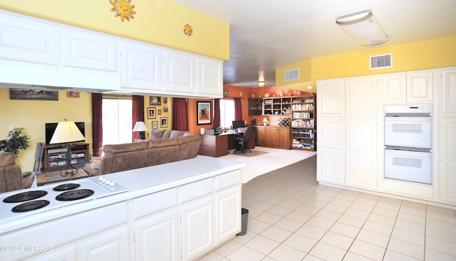 kitchen featuring white appliances, white cabinetry, and light tile patterned floors