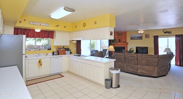 kitchen featuring a healthy amount of sunlight, white appliances, kitchen peninsula, and ceiling fan