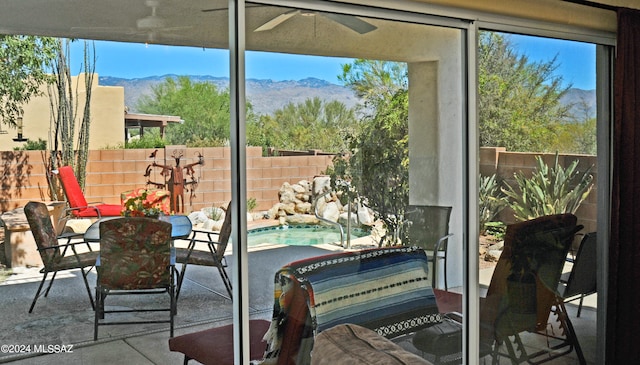 sunroom with a mountain view and ceiling fan