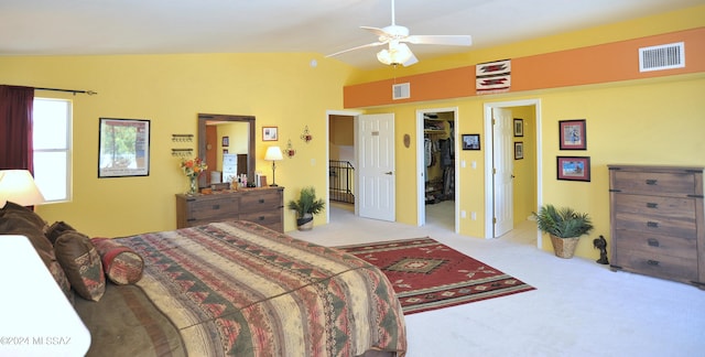 carpeted bedroom with a closet, lofted ceiling, ceiling fan, and a walk in closet