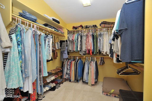 walk in closet featuring light colored carpet