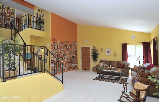 living room with high vaulted ceiling and carpet floors