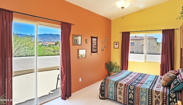 carpeted bedroom with access to outside, lofted ceiling, ceiling fan, and a mountain view