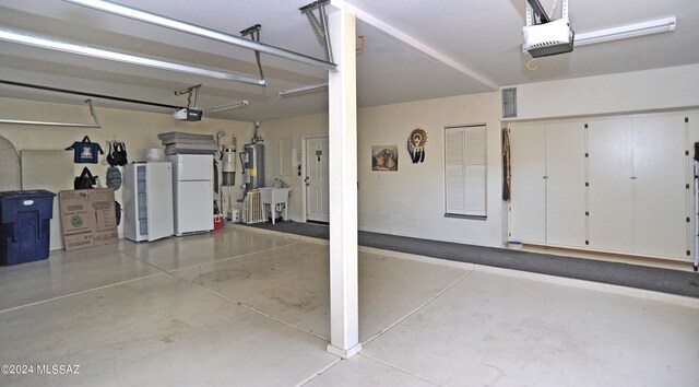 garage with a garage door opener and white refrigerator