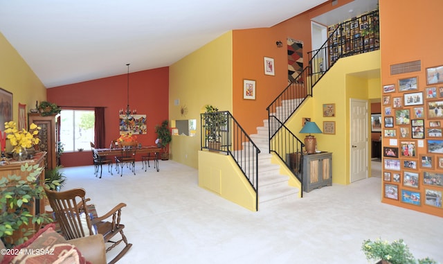 interior space with high vaulted ceiling, a chandelier, and carpet flooring