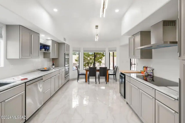 kitchen with gray cabinetry, black electric stovetop, wall chimney range hood, and stainless steel dishwasher