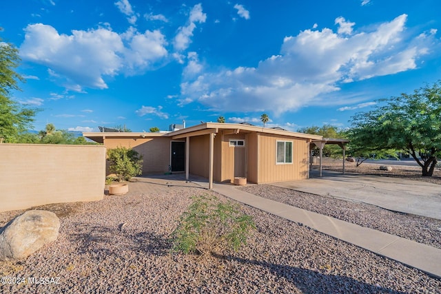 back of house featuring a patio, a carport, driveway, and fence