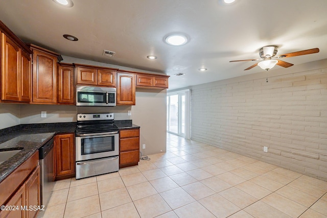 kitchen with brown cabinets, brick wall, ceiling fan, visible vents, and appliances with stainless steel finishes
