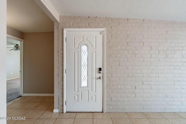entrance foyer with ceiling fan, tile patterned flooring, and baseboards