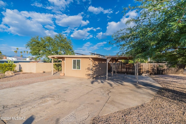 back of property with fence and driveway