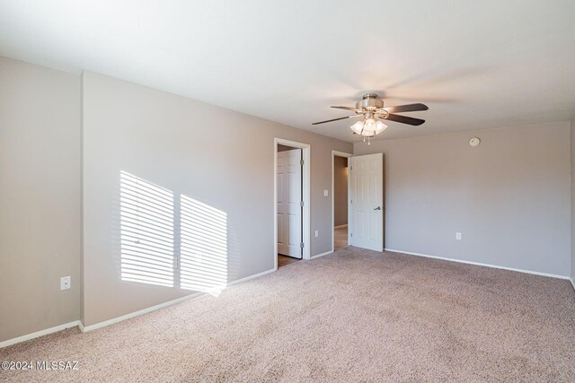spare room with baseboards, a ceiling fan, and carpet flooring