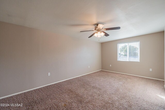 unfurnished room featuring a ceiling fan, carpet flooring, and baseboards