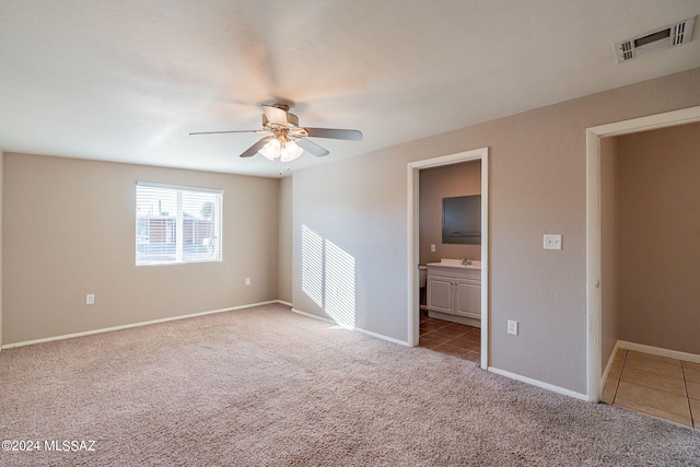 unfurnished bedroom featuring baseboards, connected bathroom, visible vents, and carpet flooring