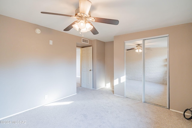 unfurnished bedroom featuring carpet, a closet, visible vents, ceiling fan, and baseboards