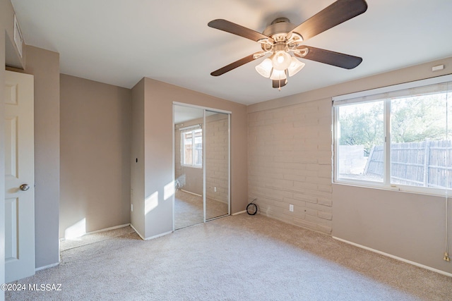 unfurnished bedroom featuring carpet, baseboards, ceiling fan, and a closet