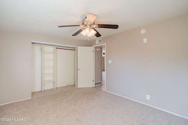 unfurnished bedroom featuring a ceiling fan, a closet, light carpet, and visible vents