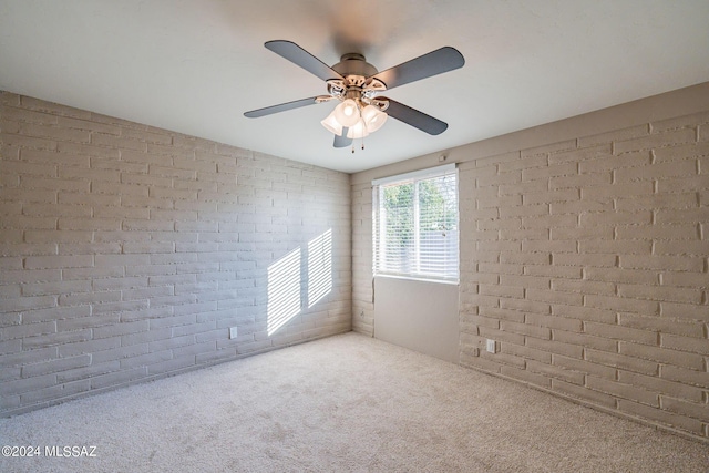 spare room with vaulted ceiling, brick wall, ceiling fan, and carpet flooring