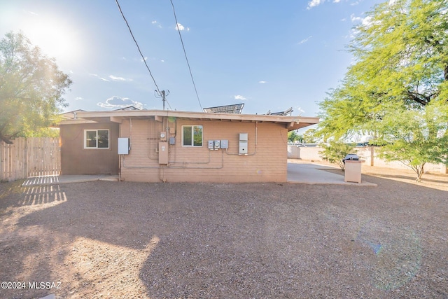 back of property featuring fence and a patio