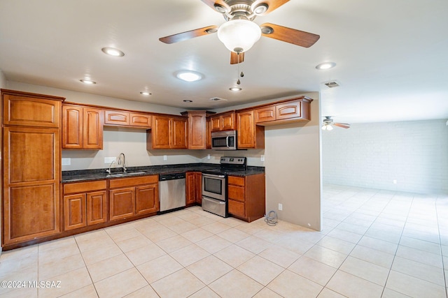 kitchen featuring brown cabinets, a sink, visible vents, stainless steel appliances, and a ceiling fan