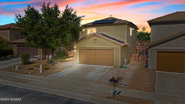 398 W Cedar Chase Dr, Green Valley, AZ 85614 - traditional-style home with concrete driveway, stucco siding, solar panels, a tile roof, and a garage