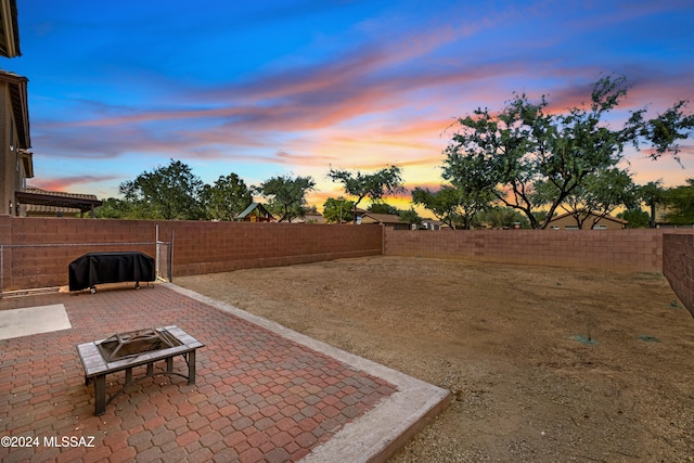 398 W Cedar Chase Dr, Green Valley, AZ 85614 - yard at dusk featuring an outdoor fire pit, a patio area, and a fenced backyard