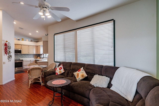 living room with vaulted ceiling, ceiling fan, and dark wood-type flooring